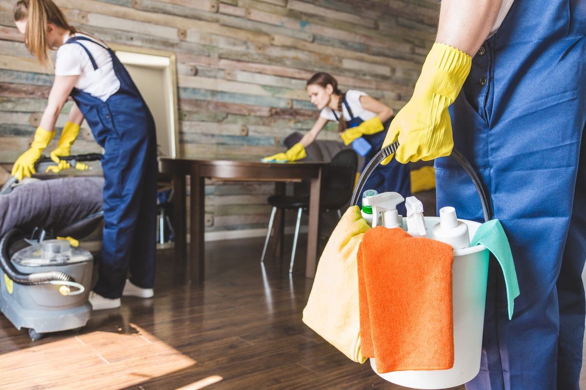 Cleaning service with professional equipment during work. professional kitchenette cleaning, sofa dry cleaning, window and floor washing. man and women in uniform, overalls and rubber gloves